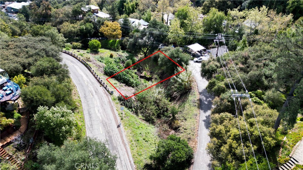 an aerial view of residential houses with outdoor space and trees