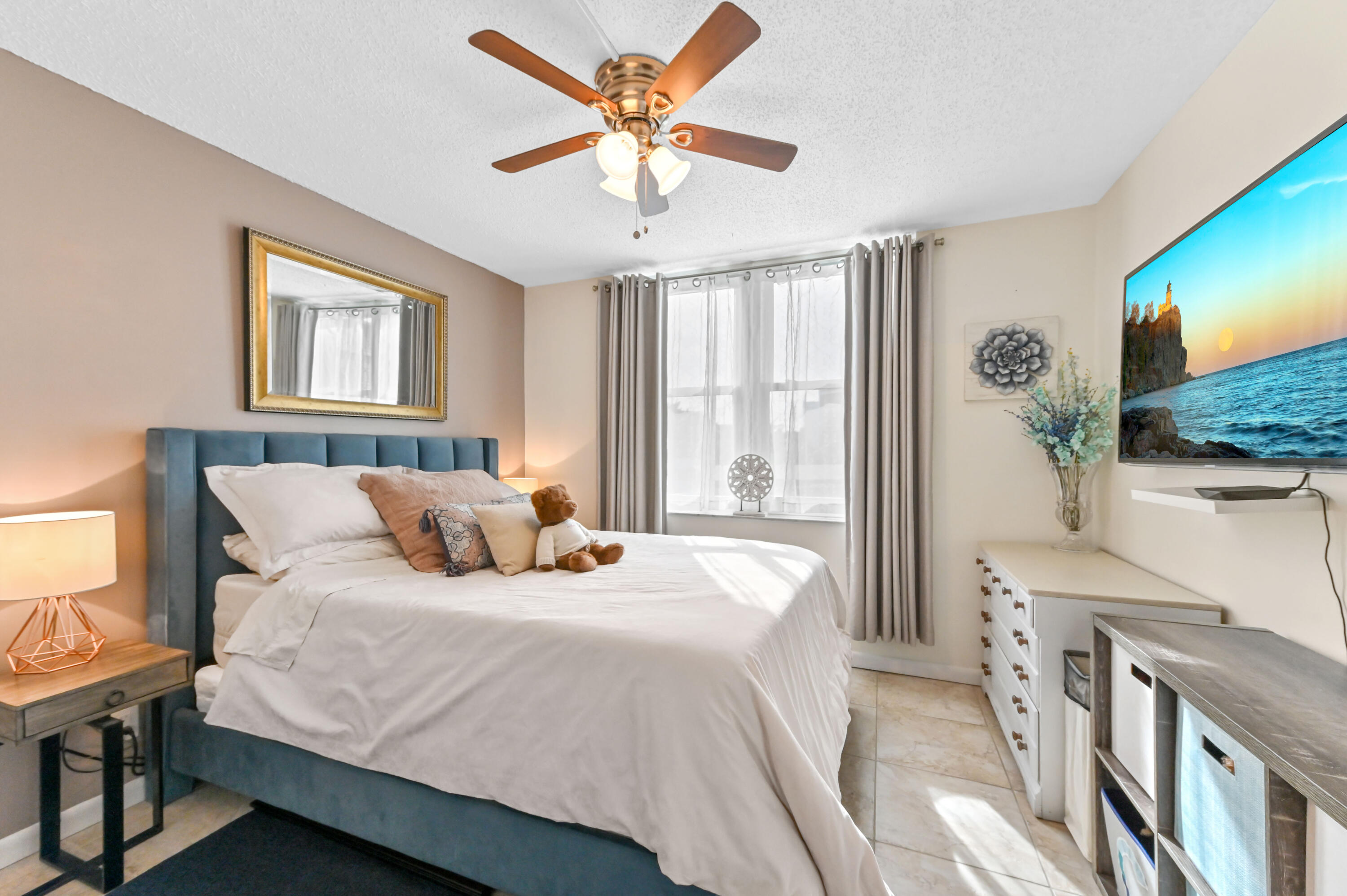 198 Northwest 67th Street, Unit 207 Boca Raton, FL 33487 - Photo 23 of 42 a bedroom with a bed and a flat screen tv
