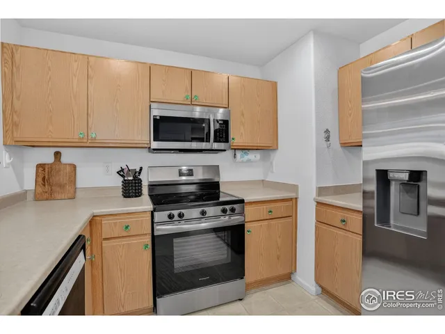 a kitchen with cabinets stainless steel appliances and a counter space