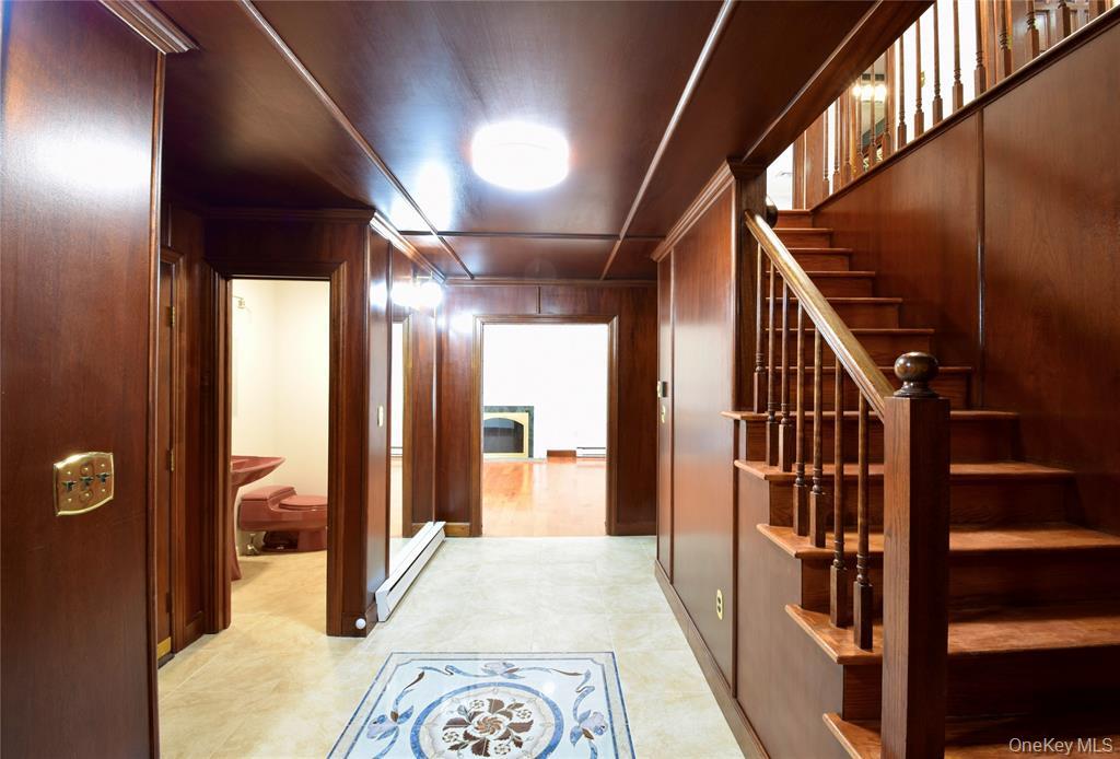 285 Goff Road Livingston Manor, NY 12758 - Photo 4 of 24 Hallway with baseboard heating, wooden walls, ornamental molding, and stairs