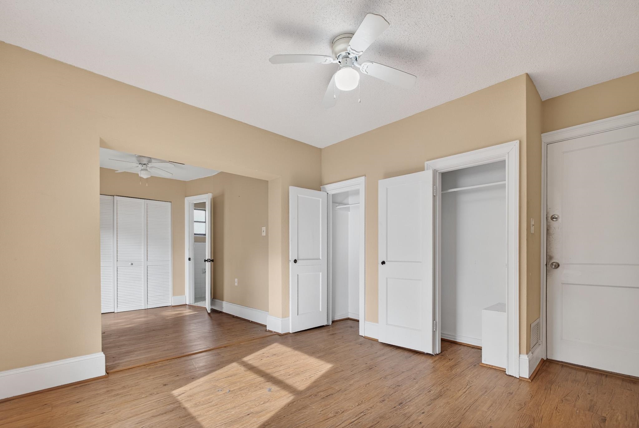 2907 North 5th Street St. Augustine, FL 32084 - Photo 19 of 71 Unfurnished bedroom featuring two closets, a ceiling fan, and light wood-style flooring