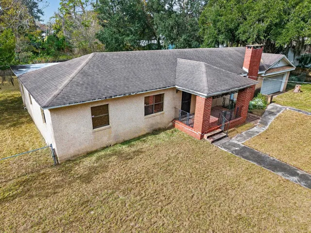 a aerial view of a house with a yard and large tree