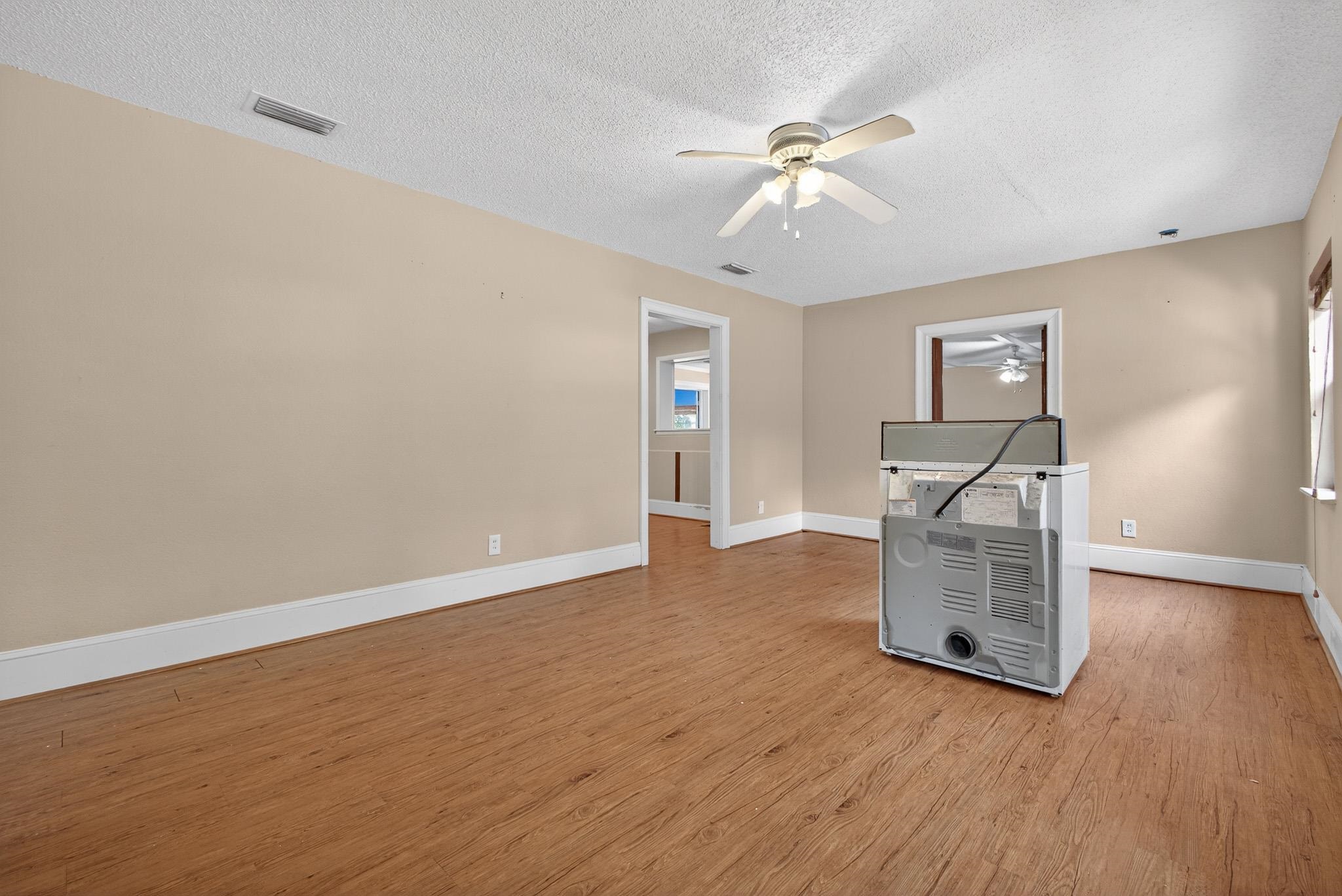 2907 North 5th Street St. Augustine, FL 32084 - Photo 27 of 71 Unfurnished living room with ceiling fan, a textured ceiling, and light wood-style flooring