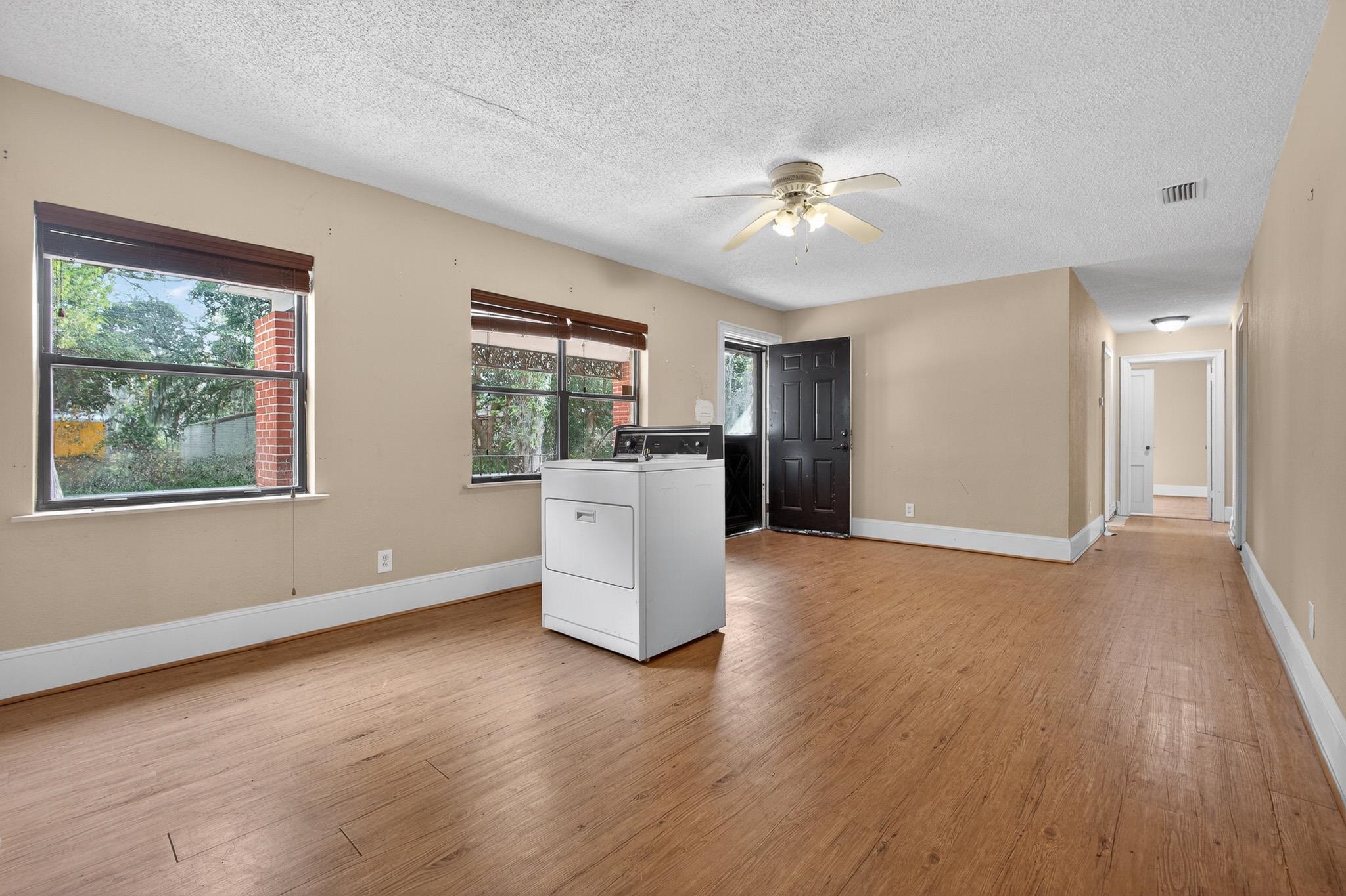 2907 North 5th Street St. Augustine, FL 32084 - Photo 30 of 71 Unfurnished living room with washer / dryer, a textured ceiling, light wood finished floors, and ceiling fan