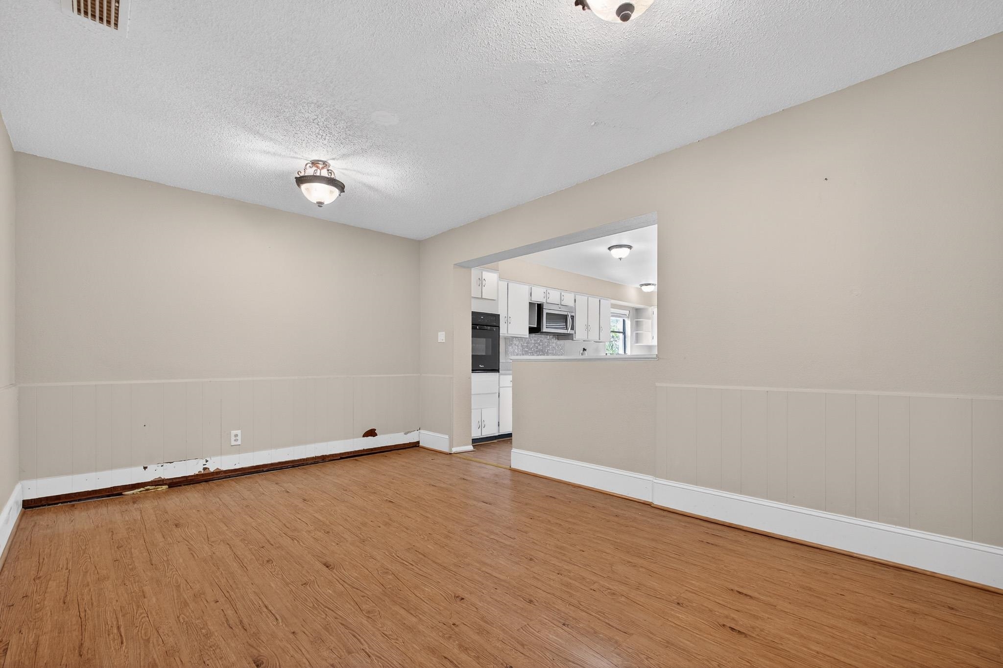 2907 North 5th Street St. Augustine, FL 32084 - Photo 31 of 71 Empty room with wainscoting, a textured ceiling, and light wood finished floors