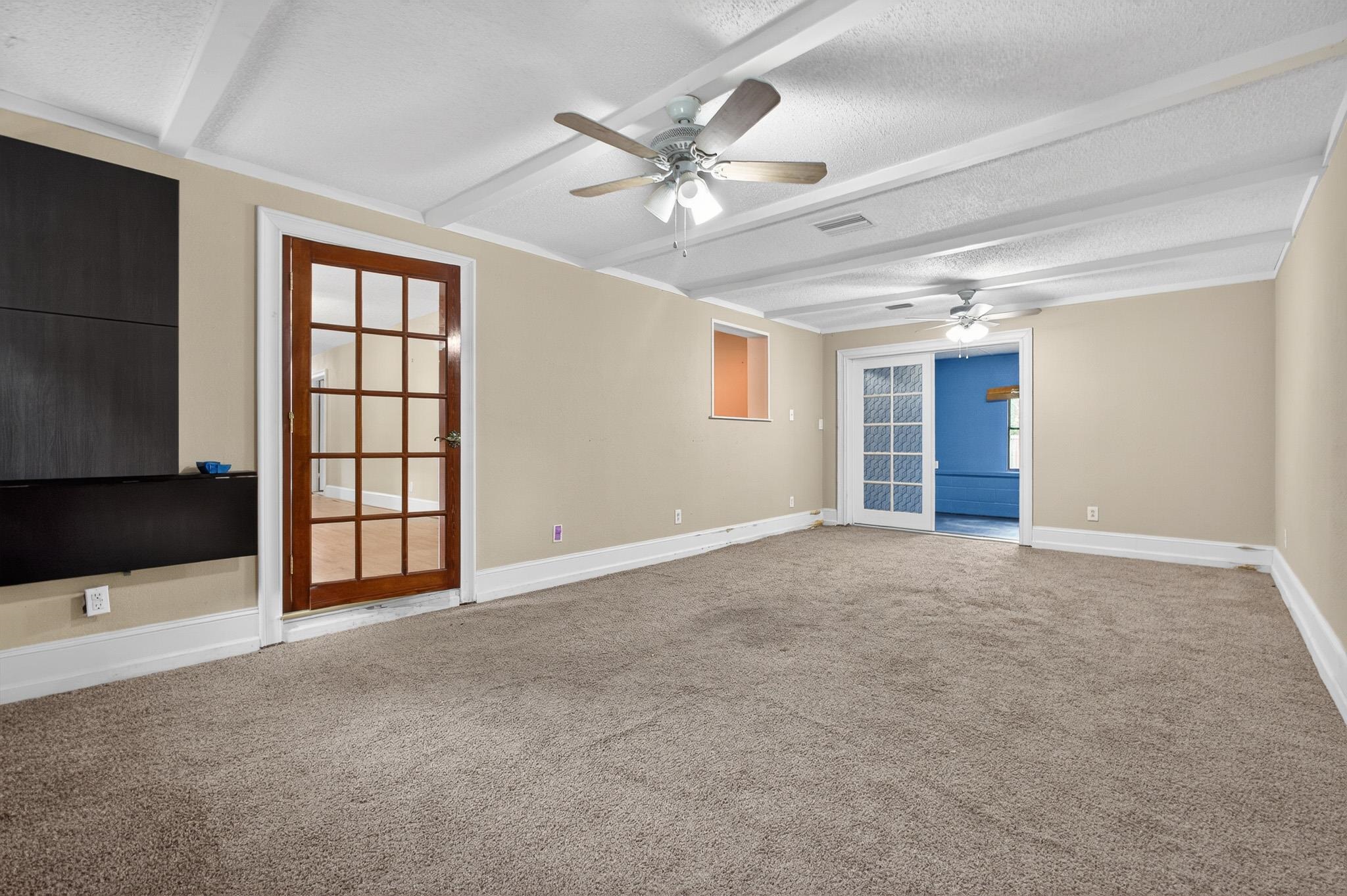 2907 North 5th Street St. Augustine, FL 32084 - Photo 38 of 71 Carpeted spare room featuring beam ceiling, a textured ceiling, and a ceiling fan