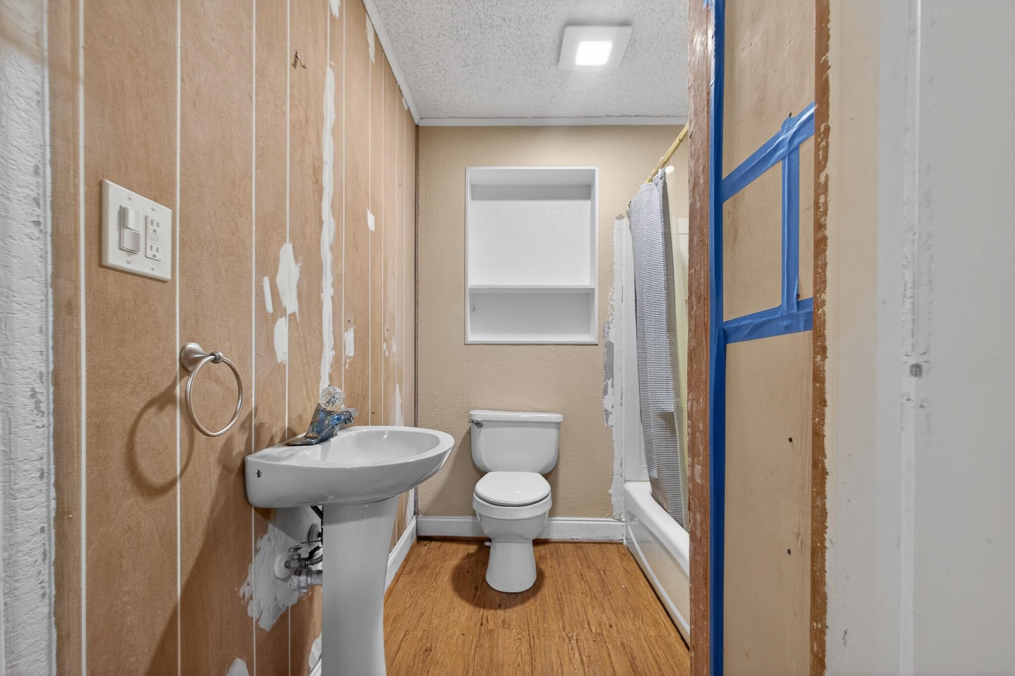 2907 North 5th Street St. Augustine, FL 32084 - Photo 42 of 71 Full bathroom featuring a textured ceiling, wood finished floors, shower / tub combo, and wooden walls