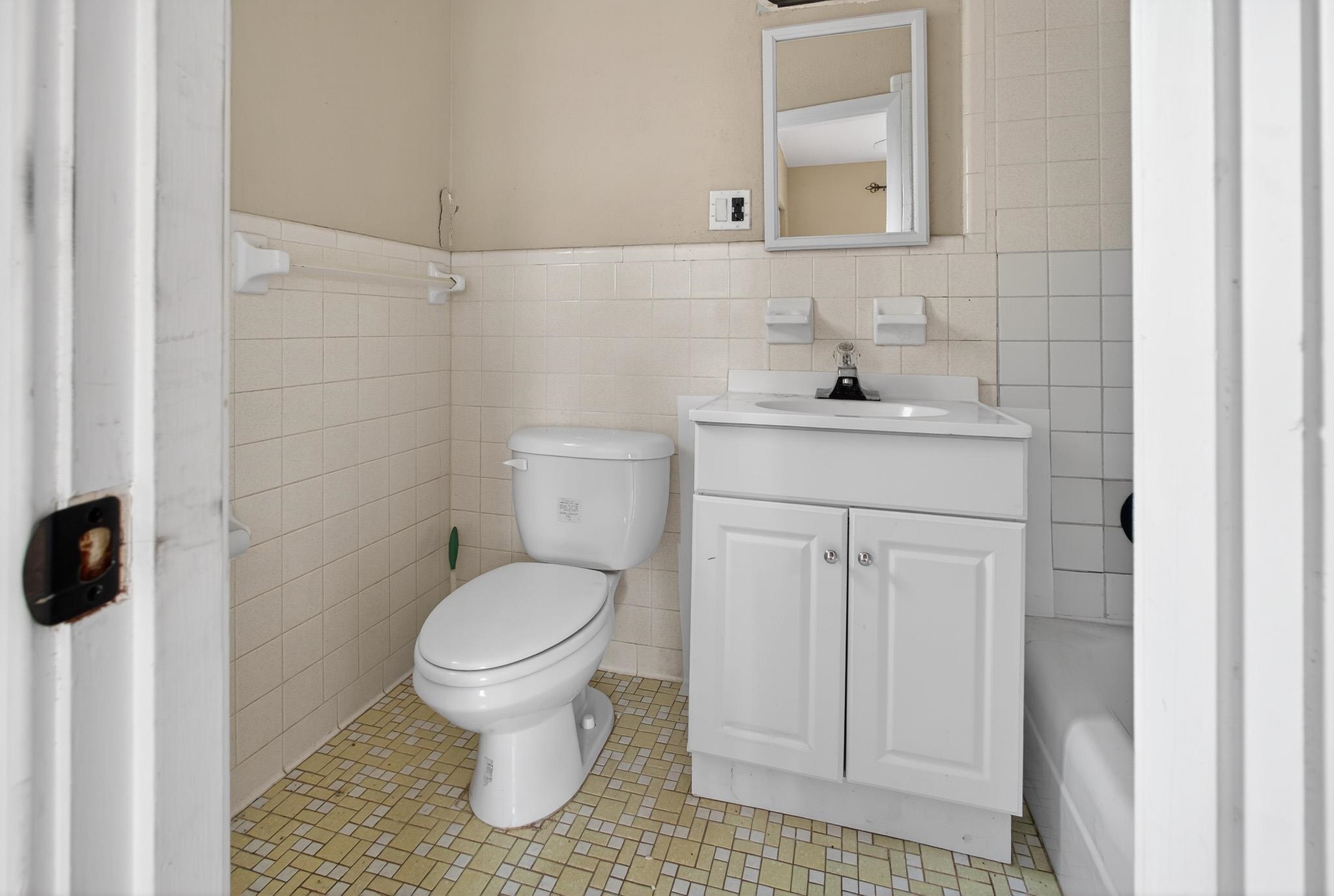 2907 North 5th Street St. Augustine, FL 32084 - Photo 43 of 71 Full bath featuring tile walls, vanity, a wainscoted wall, and a bathtub