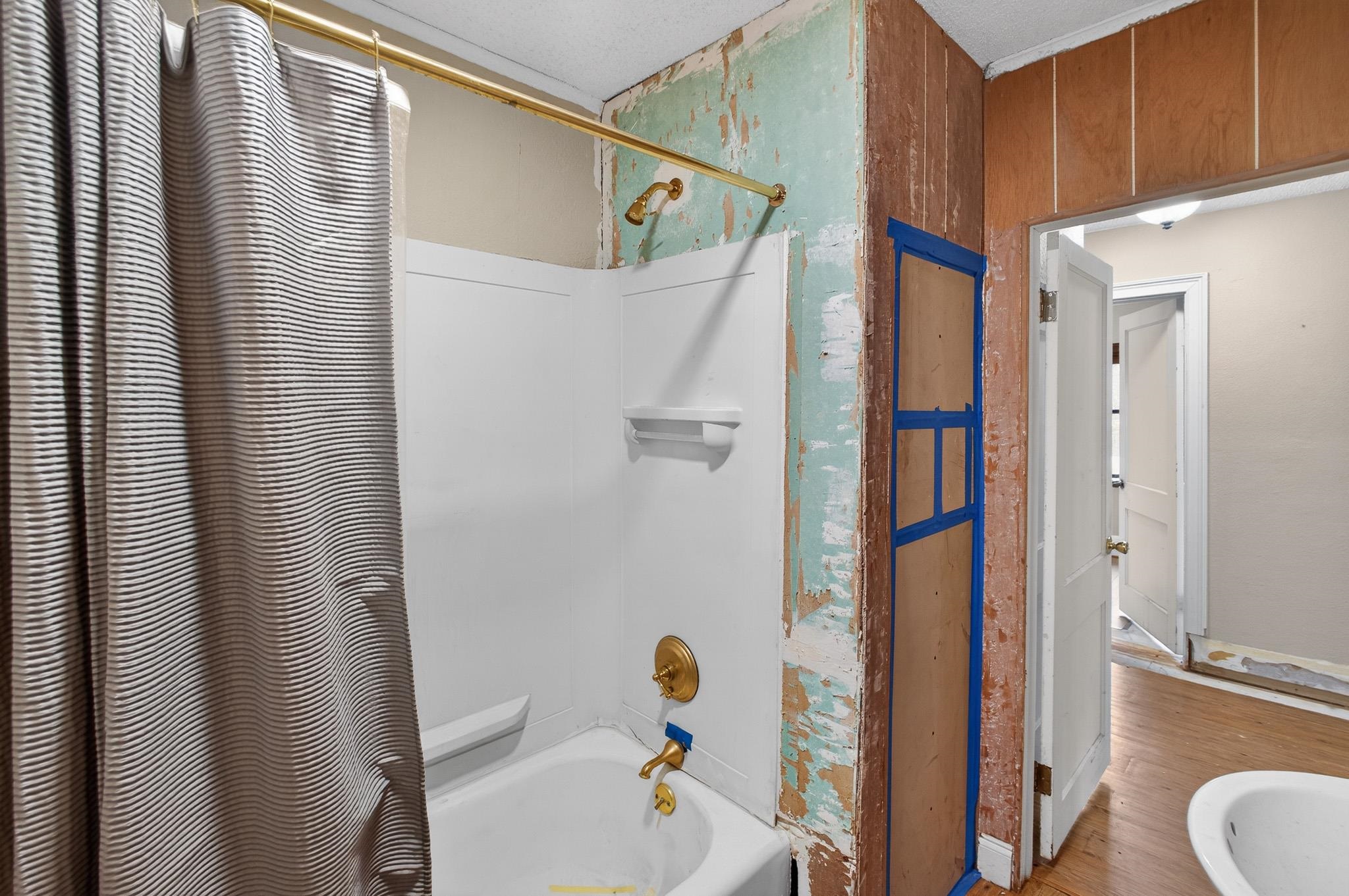2907 North 5th Street St. Augustine, FL 32084 - Photo 45 of 71 Bathroom with shower / bathtub combination with curtain and wood finished floors