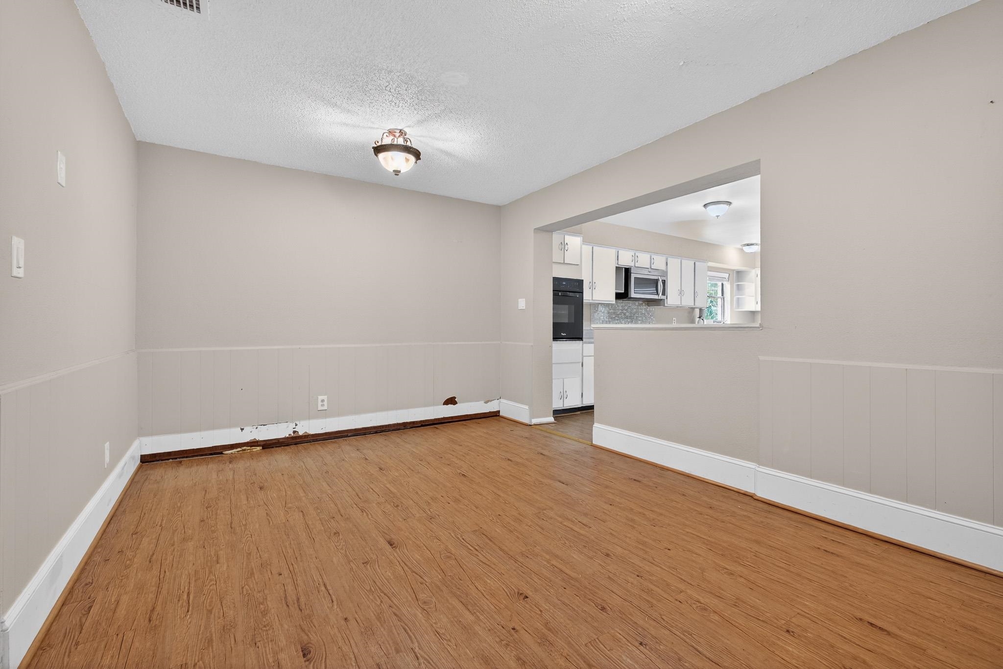 2907 North 5th Street St. Augustine, FL 32084 - Photo 50 of 71 Spare room featuring light wood-type flooring, a wainscoted wall, and a textured ceiling