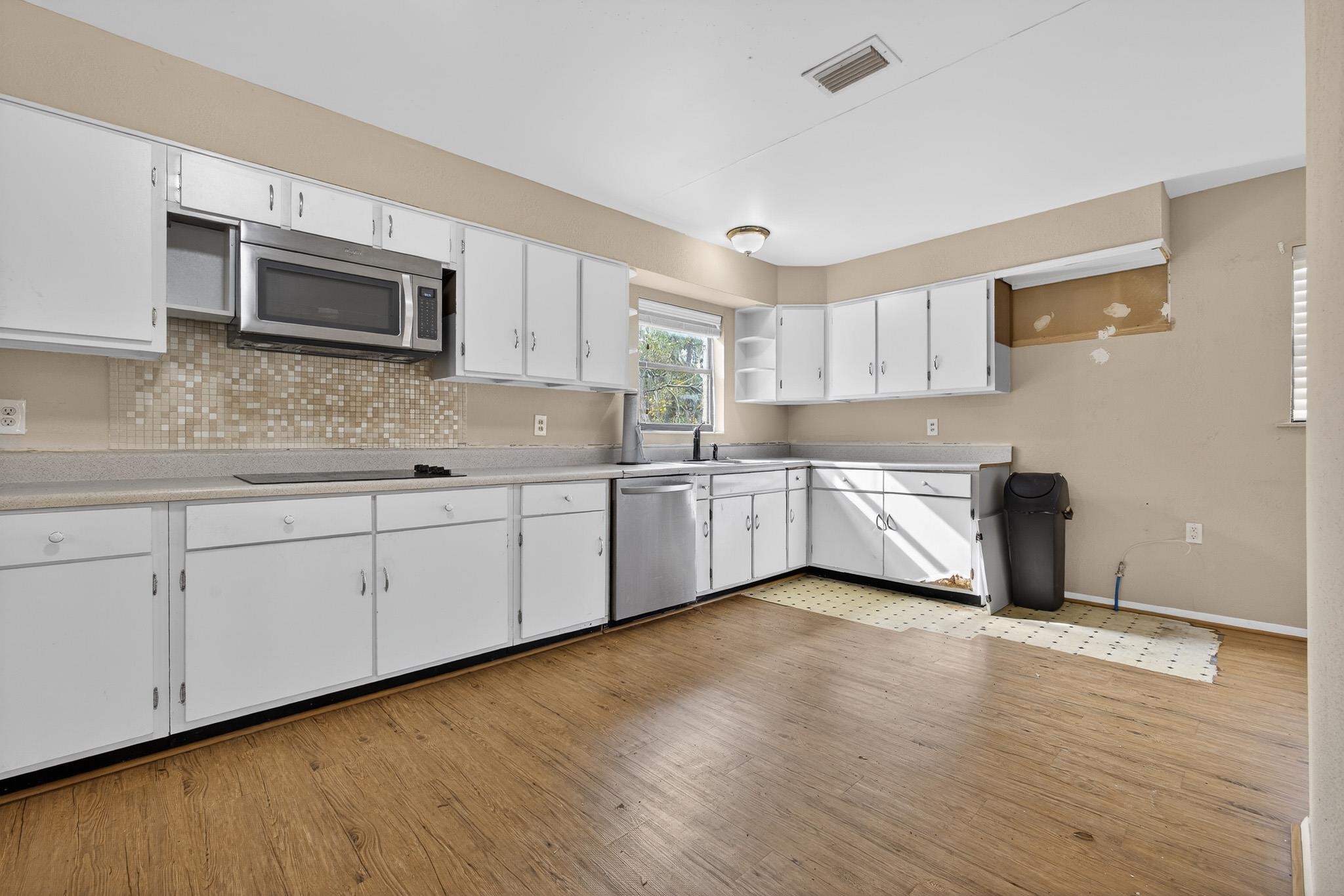 2907 North 5th Street St. Augustine, FL 32084 - Photo 6 of 71 Kitchen with white cabinetry, light countertops, open shelves, appliances with stainless steel finishes, and light wood-style flooring
