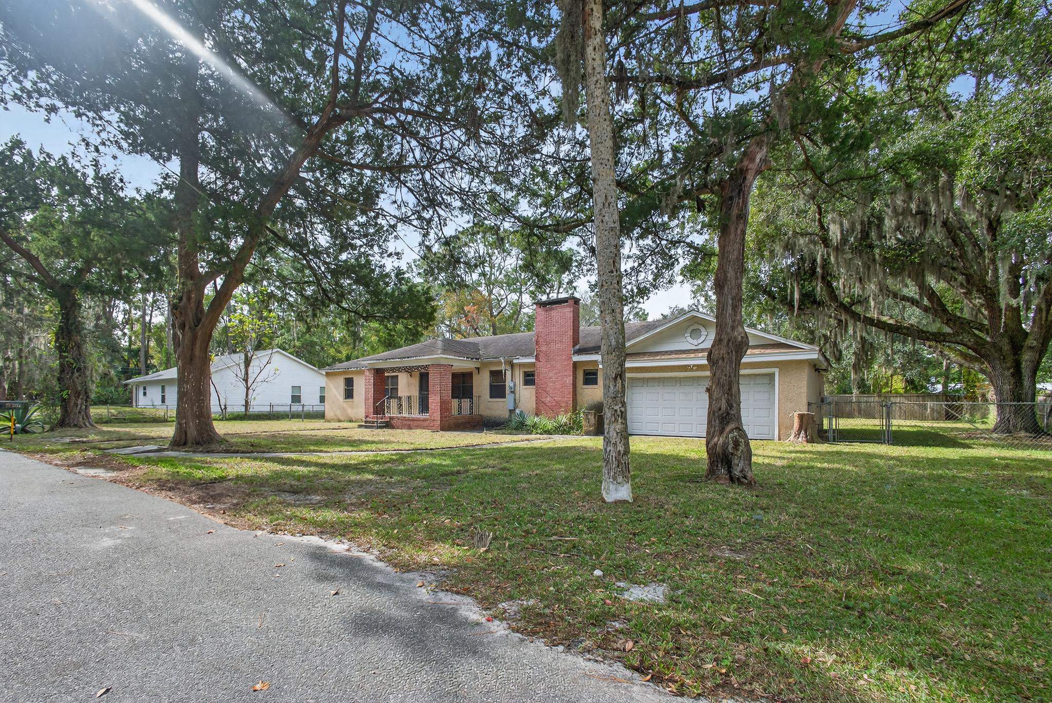 2907 North 5th Street St. Augustine, FL 32084 - Photo 65 of 71 Ranch-style house with a chimney, brick siding, view of wooded area, and an attached garage