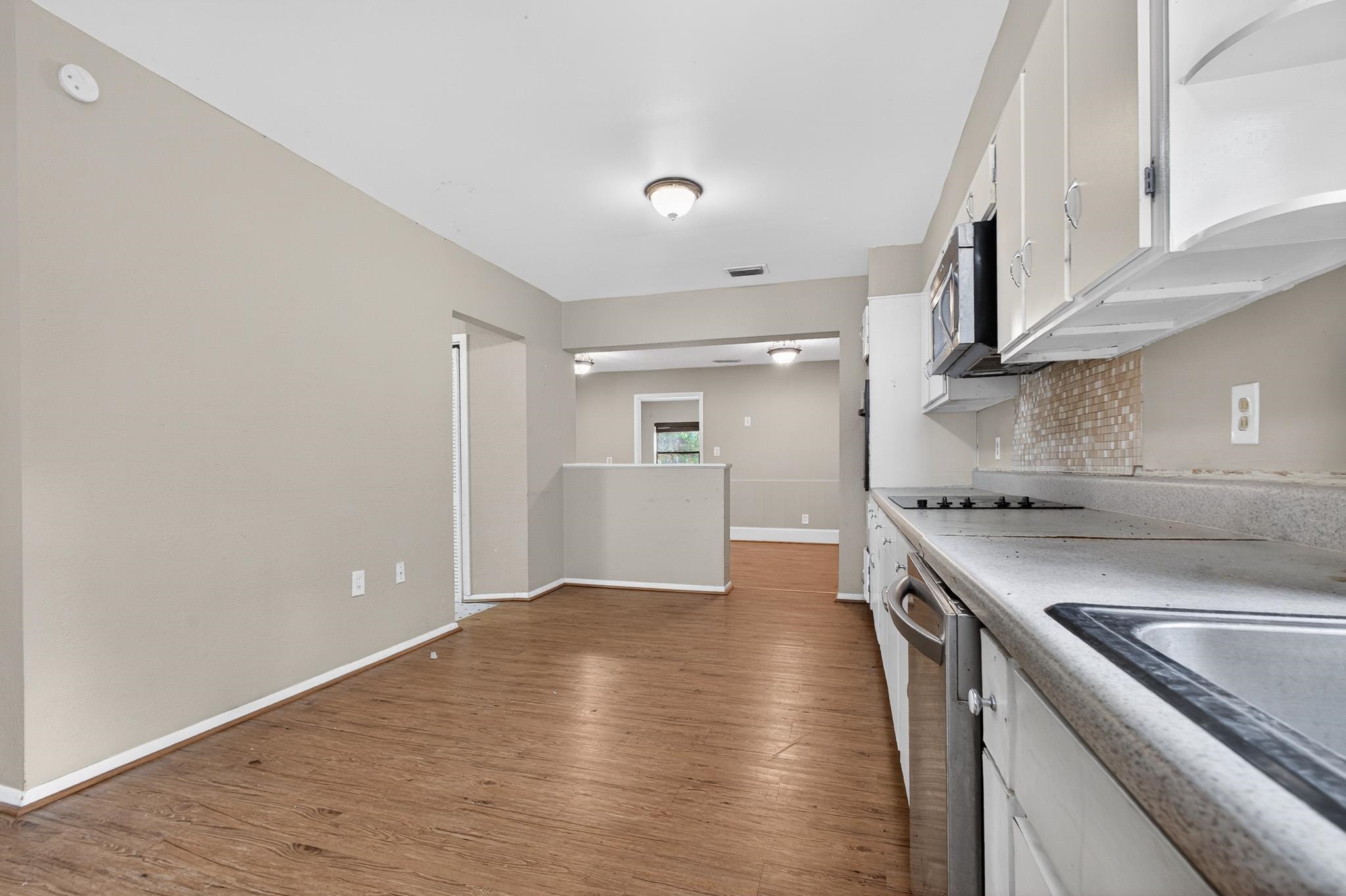 2907 North 5th Street St. Augustine, FL 32084 - Photo 7 of 71 Kitchen featuring white cabinets, light wood-type flooring, light countertops, and appliances with stainless steel finishes