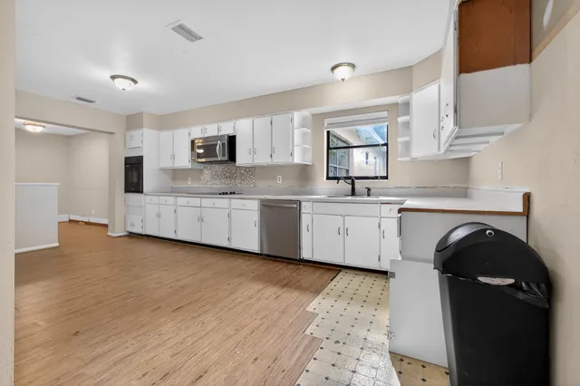 a view of an empty room with wooden floor and closet