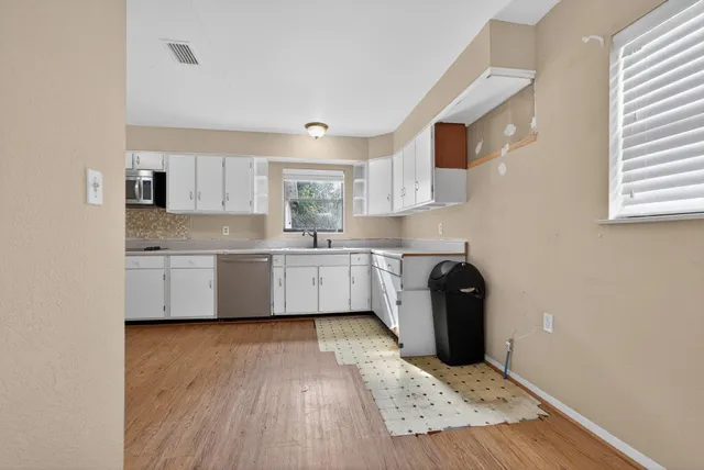 a view of an empty room with wooden floor
