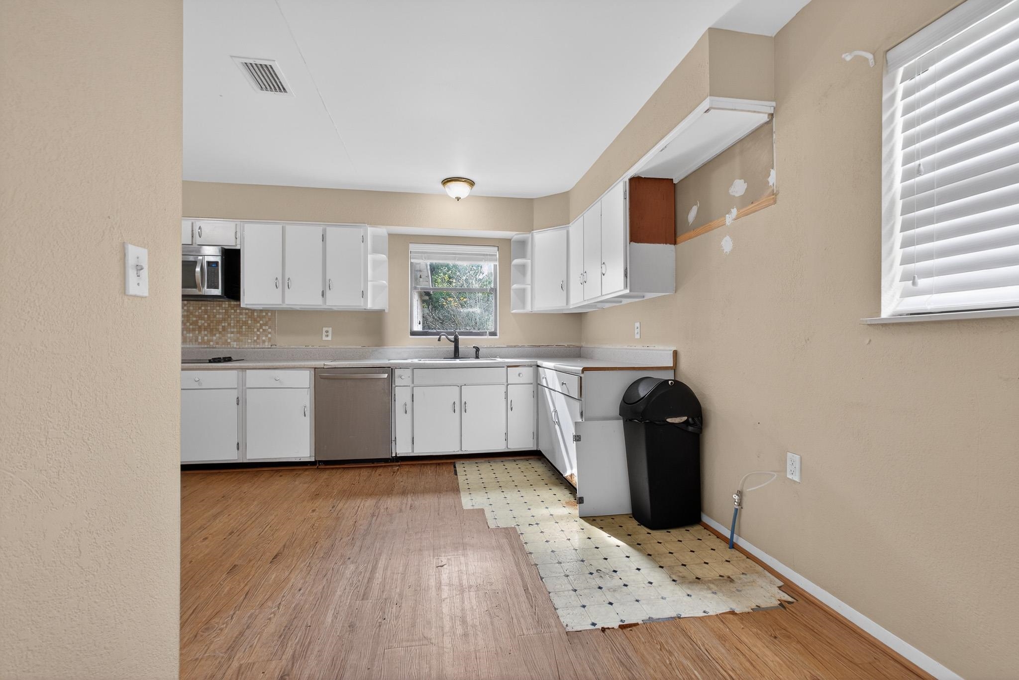 2907 North 5th Street St. Augustine, FL 32084 - Photo 9 of 71 Kitchen featuring open shelves, white cabinetry, light countertops, appliances with stainless steel finishes, and light wood finished floors