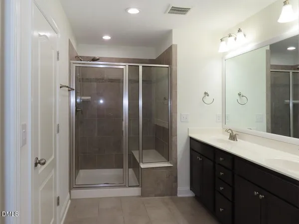 a bathroom with a double vanity sink mirror and shower