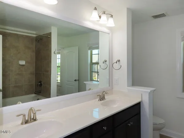 a bathroom with a granite countertop sink a toilet and a mirror