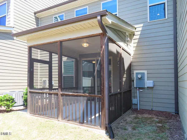 a view of a house with large windows and wooden fence