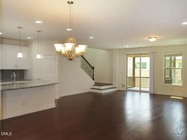 a view of a room with wooden floor and chandelier