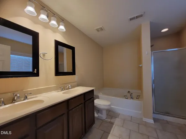 a bathroom with a tub double sink and mirror