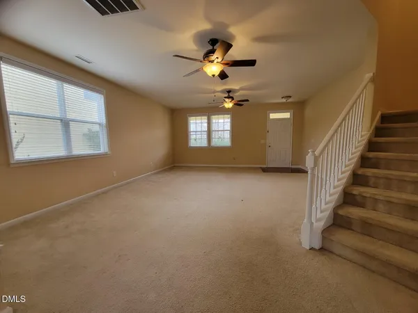 an empty room with windows and fan