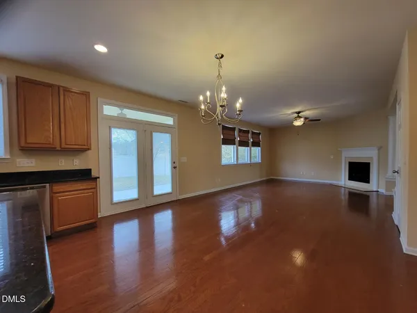 a view of a kitchen with granite countertop wooden floor and stainless steel appliances