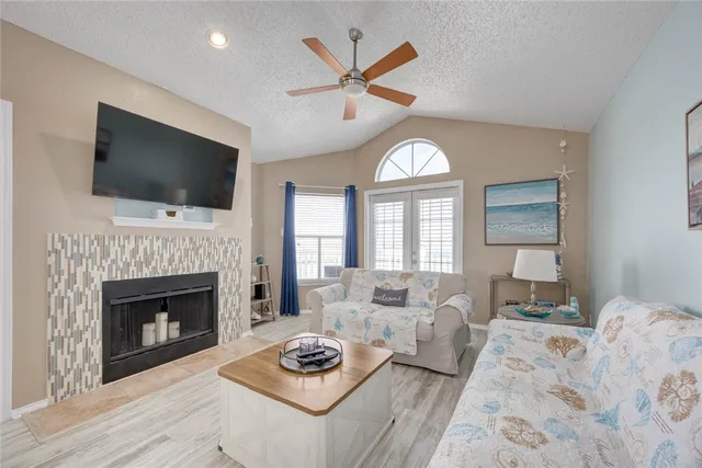 a living room with furniture a fireplace and a flat screen tv
