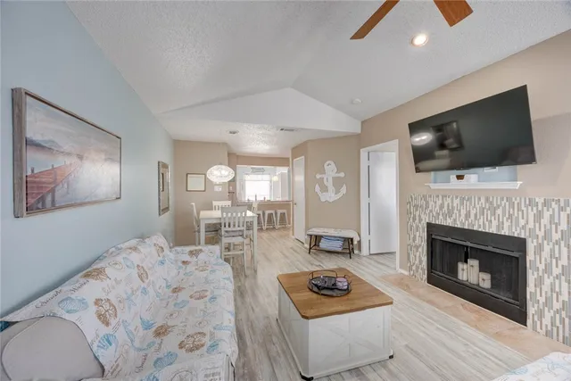a living room with furniture a flat screen tv and a fireplace