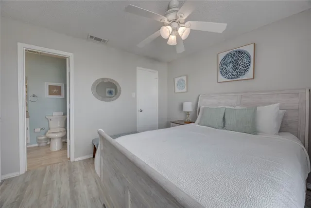 a bedroom with a large bed and a chandelier