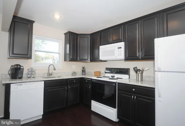 a kitchen with a sink a stove a refrigerator and cabinets