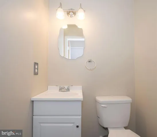 a bathroom with a toilet a sink and mirror