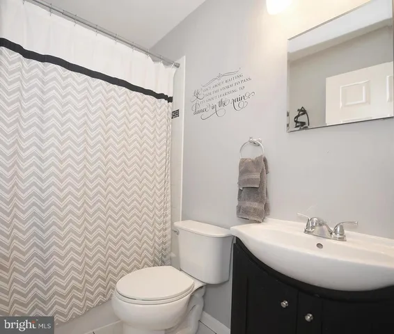 a bathroom with a sink toilet and a mirror