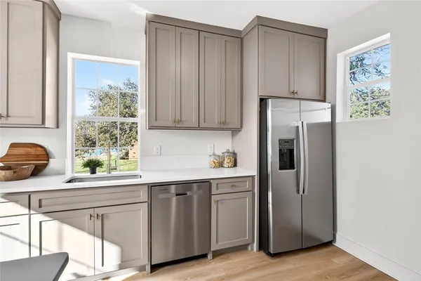 a kitchen with stainless steel appliances a sink a stove a refrigerator and cabinets
