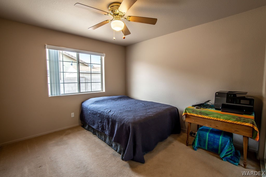 4213 East Cane Ranch Road Kingman, AZ 86401 - Photo 14 of 40 a bedroom with a bed and a chandelier