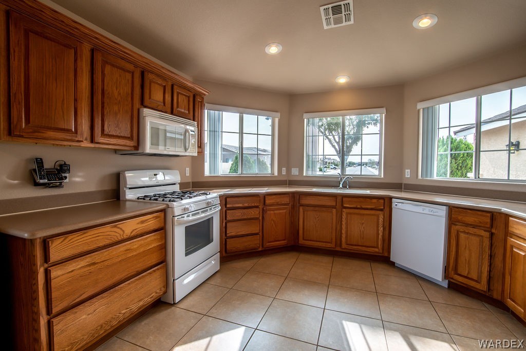 4213 East Cane Ranch Road Kingman, AZ 86401 - Photo 4 of 40 a kitchen with stainless steel appliances granite countertop wooden cabinets a sink and a stove