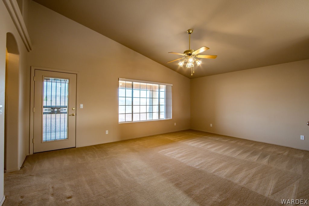 4213 East Cane Ranch Road Kingman, AZ 86401 - Photo 8 of 40 an empty room with chandelier fan and windows
