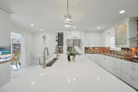 a kitchen with a sink stainless steel appliances and white cabinets