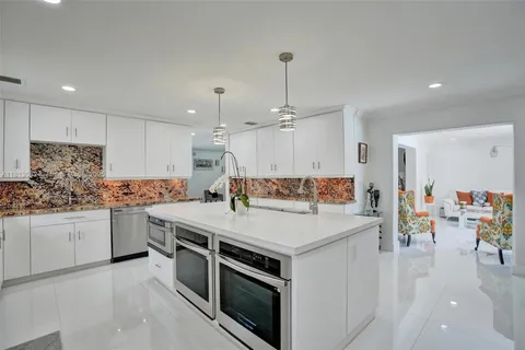 a kitchen with white cabinets and white appliances