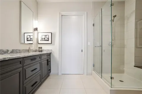 a bathroom with a granite countertop sink a mirror and a bathtub