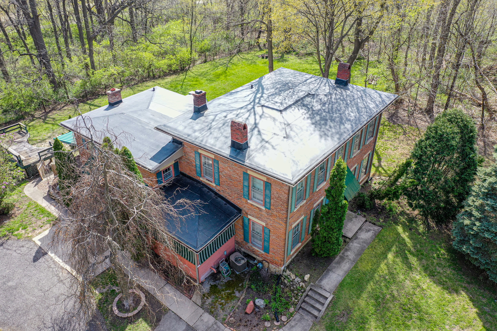 an aerial view of a house with balcony and trees