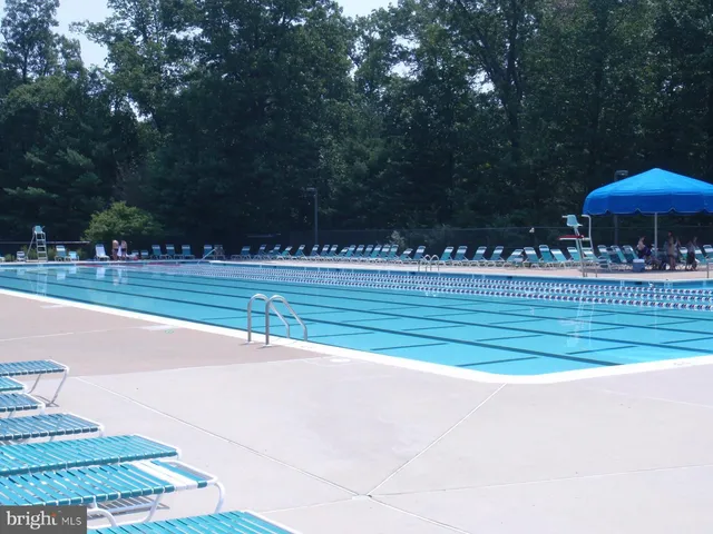 a small pool with table and chairs under an umbrella