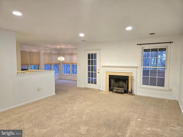 an empty room with a fireplace and window