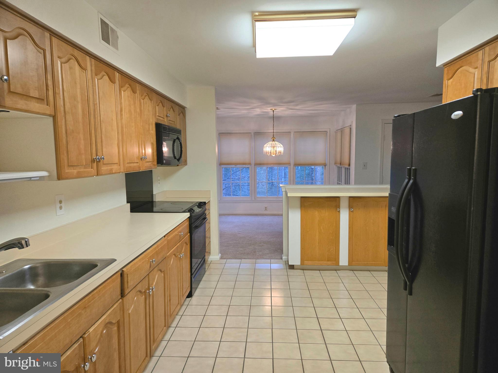 1537 Church Hill Place, Unit 1537 Reston, VA 20194 - Photo 5 of 40 a kitchen with stainless steel appliances a refrigerator sink and cabinets