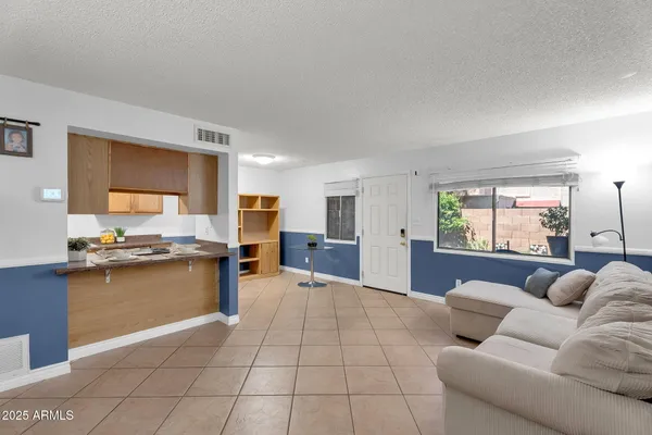 a large living room with stainless steel appliances granite countertop furniture and a large window