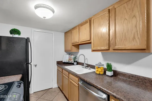a kitchen with stainless steel appliances granite countertop a sink a refrigerator and a stove
