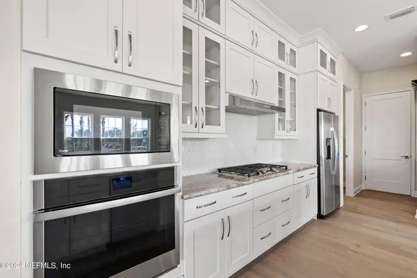 a kitchen with stainless steel appliances white cabinets and a stove