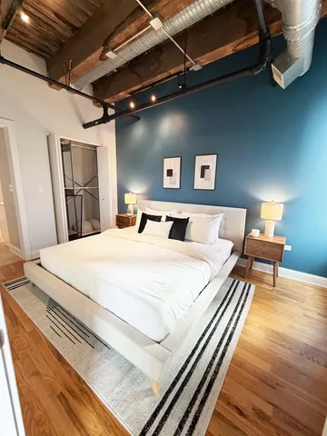 a bedroom with a bed and wooden floor