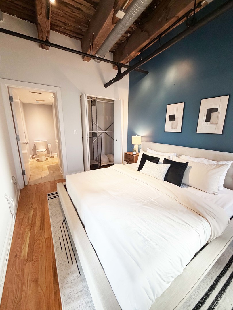 106 North Aberdeen Street, Unit 5G Chicago, IL 60607 - Photo 14 of 21 a bed room with a bed and a mirror