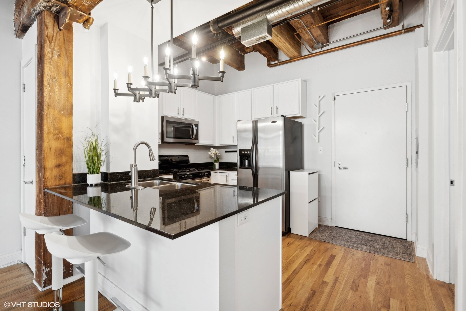 106 North Aberdeen Street, Unit 5G Chicago, IL 60607 - Photo 8 of 21 a kitchen with stainless steel appliances granite countertop a refrigerator a stove and a sink with wooden floor